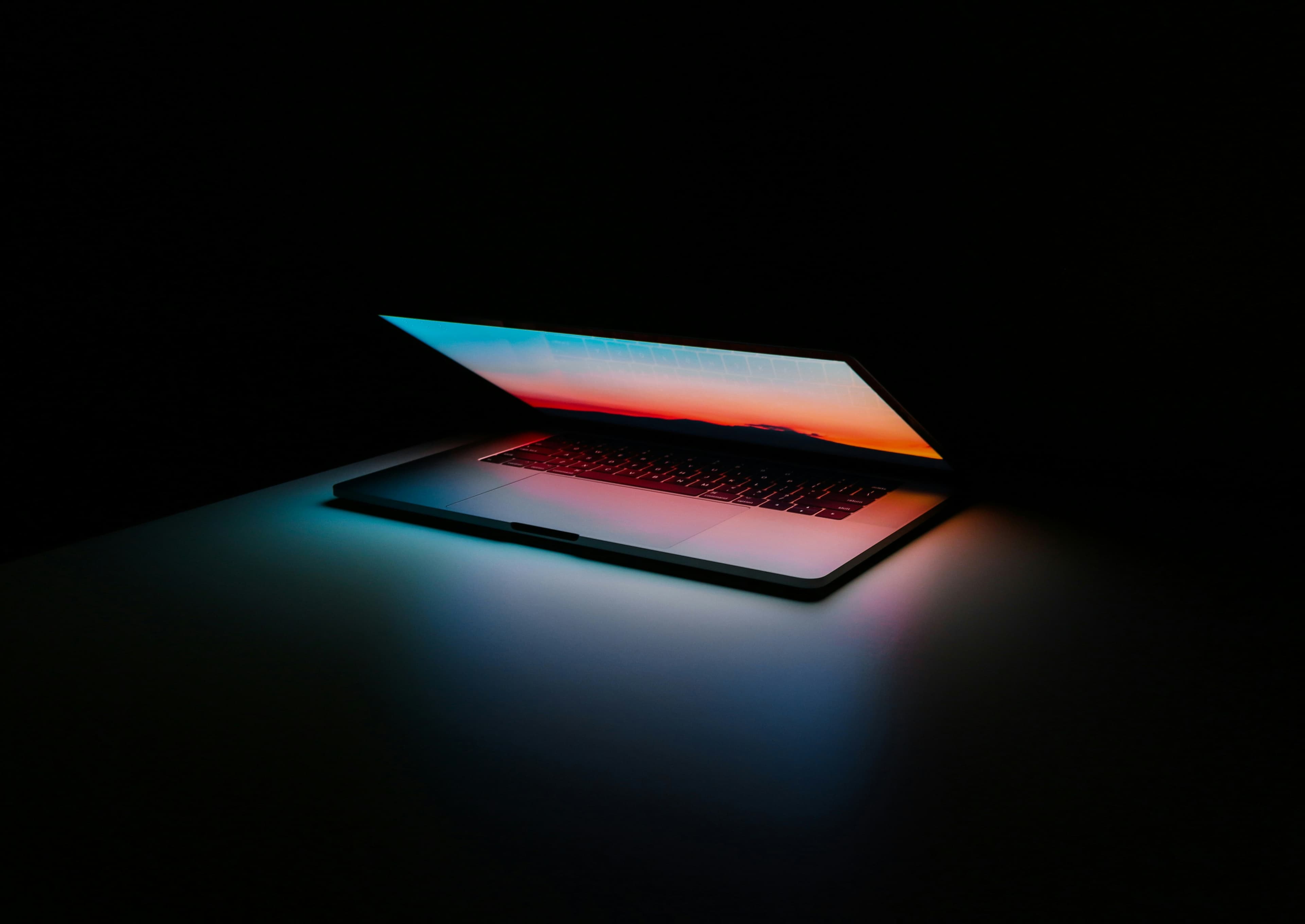 Laptop glowing in a dark room